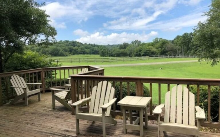 Adirondack chairs on deck overlooking green pasture