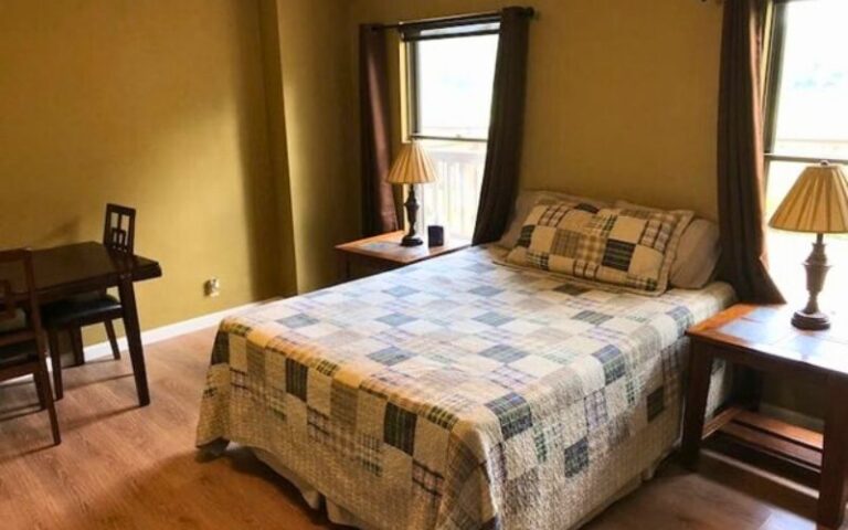 Cozy bedroom with patchwork quilt and lamps