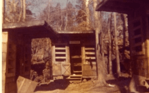 Rustic wooden building in woods.
