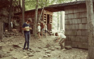 Kids at a rustic wooden cabin.