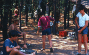 Teen boys at summer camp in woods.