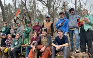 Volunteer crew posing with chainsaws in forest