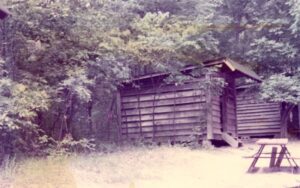 Wooden outhouses in a wooded area.