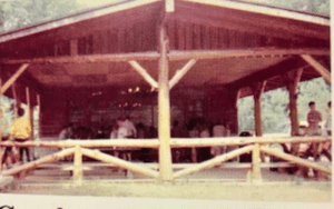Rustic pavilion with people gathered inside.