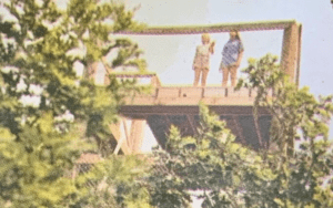 Two girls on a treetop platform.