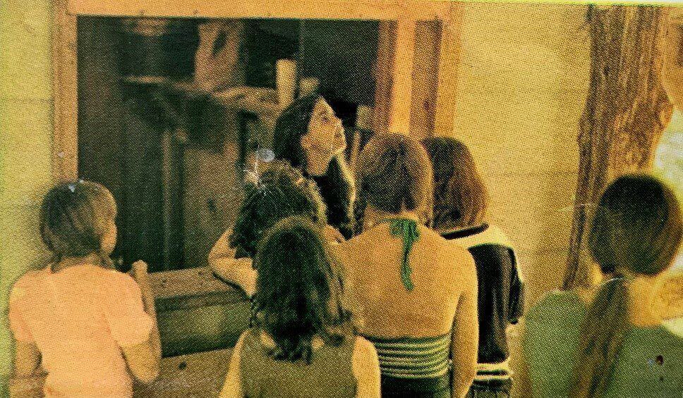 Four girls looking at a doorway.