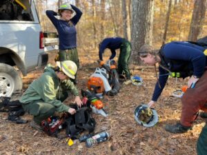 Wildfire crew prepping equipment in woods.