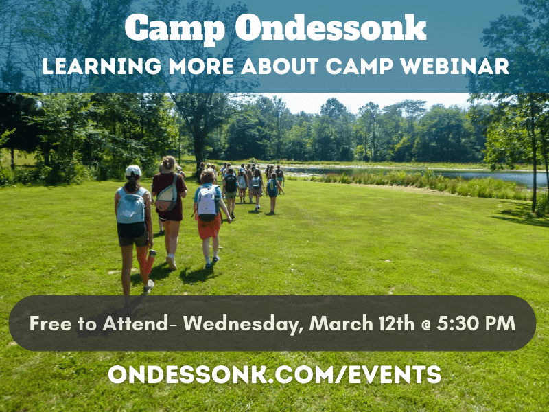 Backpacked campers walking across green field