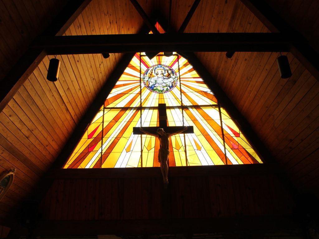 Stained glass window with Jesus on cross.