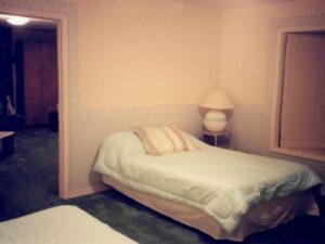 Bedroom with a bed, lamp, and window.