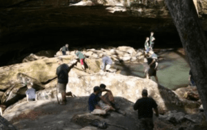 People hiking near a rocky river.