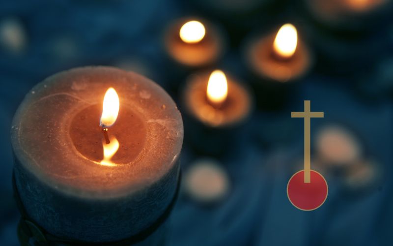 Close-up burning candle with cross symbol