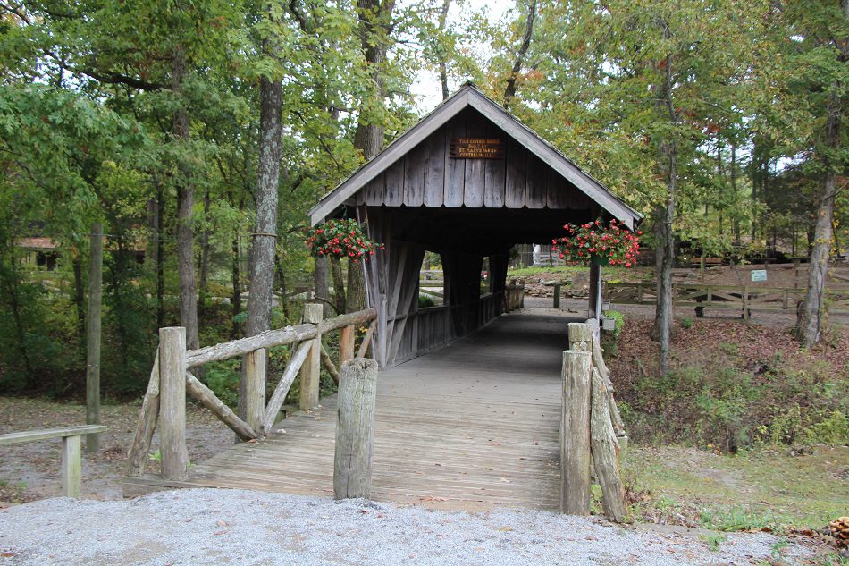 Rustic covered wooden bridge with hanging flowers