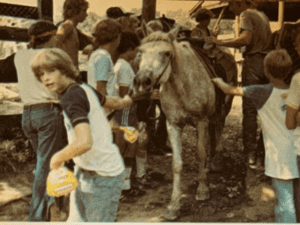 Group of kids at a farm with a horse.