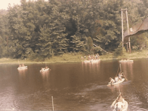 People boating on a lake near a bridge.