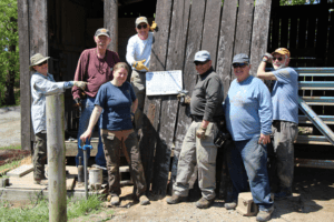Group of people standing outside a barn.