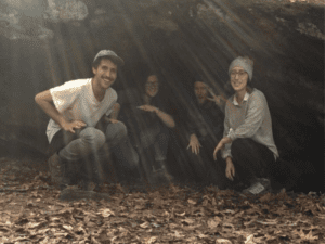 Four people smiling in a cave.