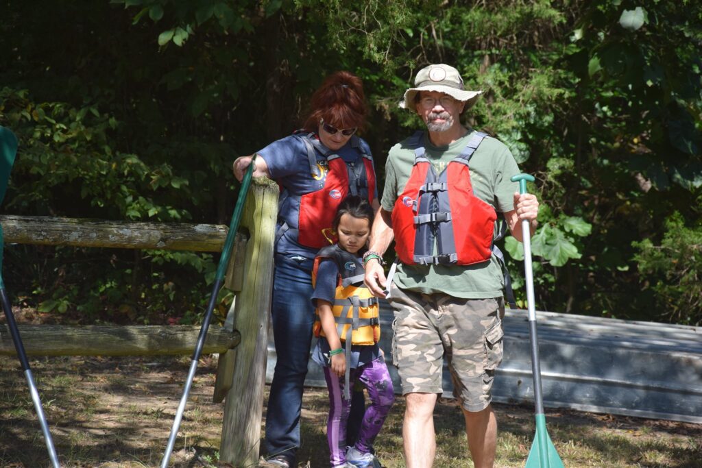 Family paddling with life jackets on.