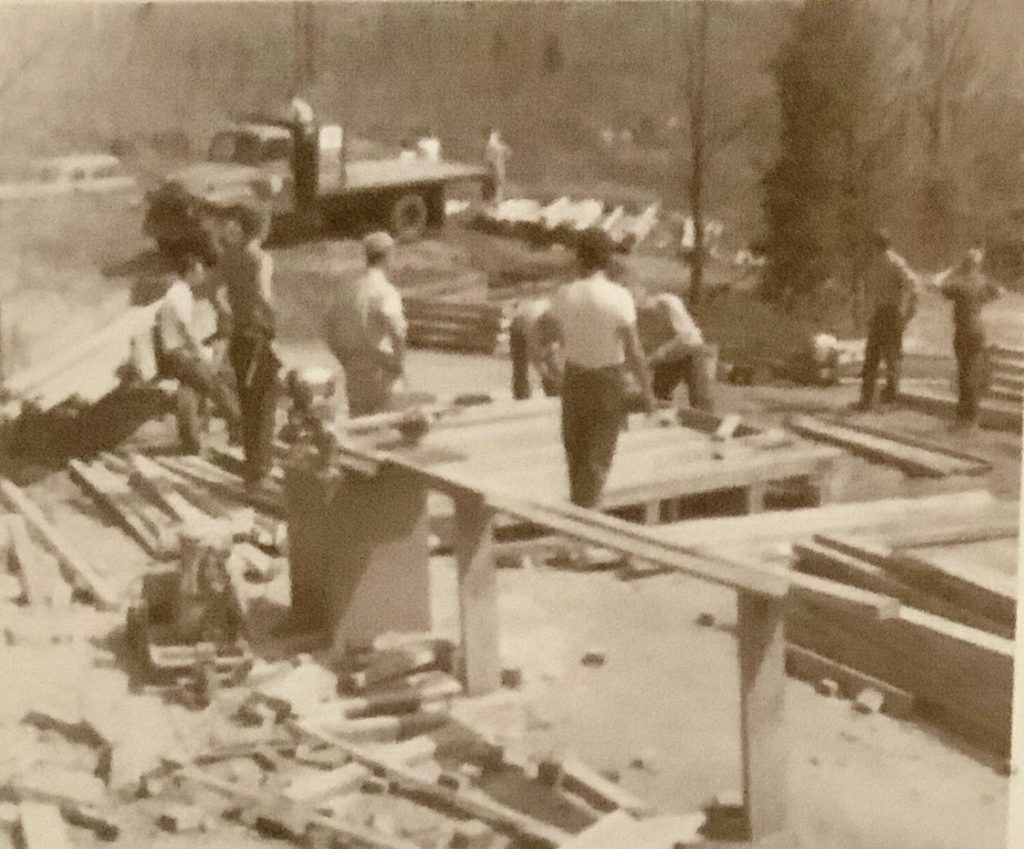 Black and white photo of men working on a construction site.
