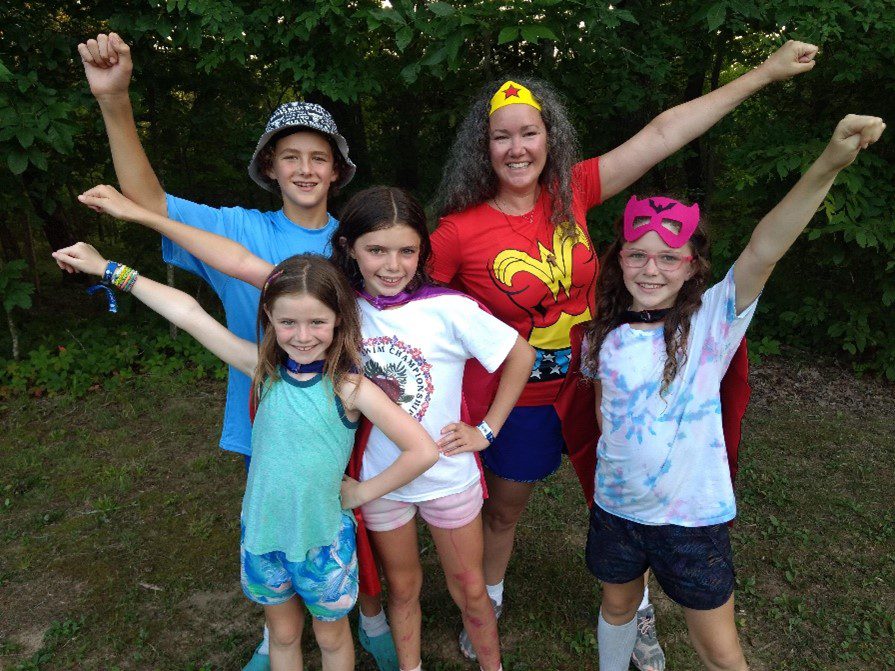 A group of kids, including Margaret, in superhero costumes posing for a photo.