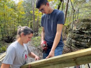 Two people building a wooden structure.