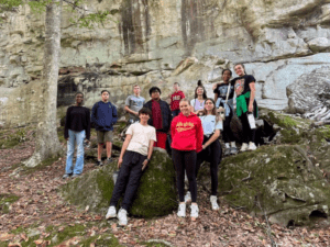 Teenagers hiking near a rock face.