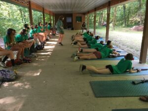 Girls in green shirts learning to shoot.