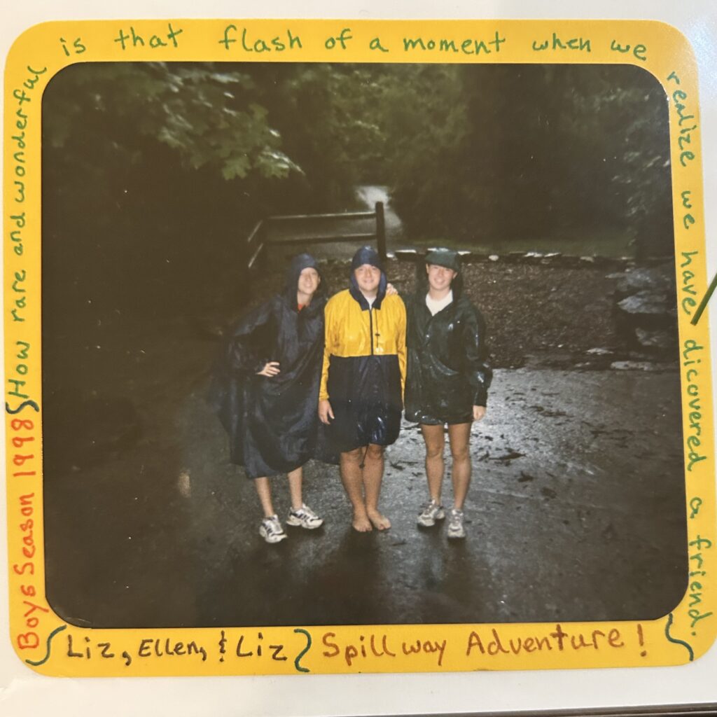 Three friends in raincoats by waterfall