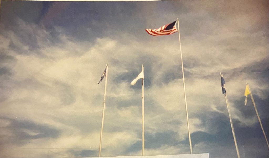 American flag and other flags against sky