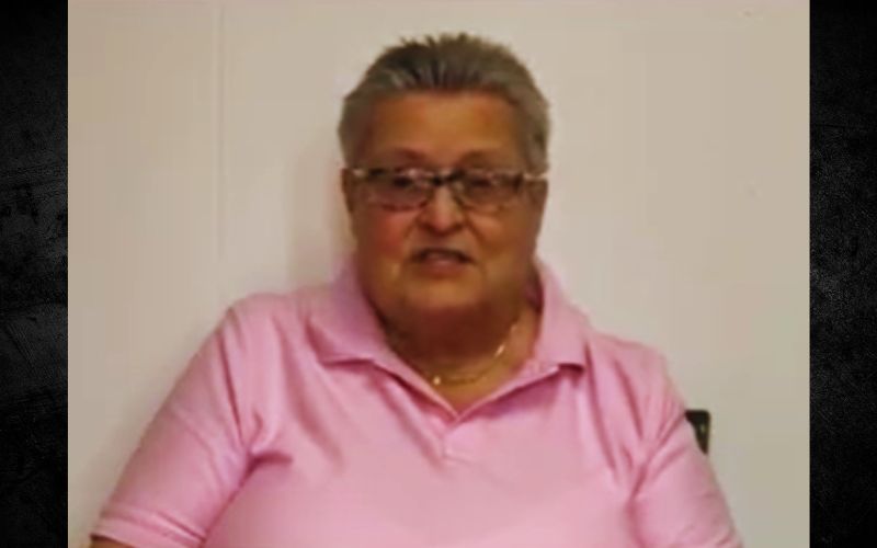 Person wearing pink shirt and glasses, smiling.