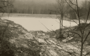 Frozen pond, winter landscape, bare trees.