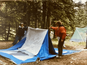 People setting up a tent in a forest.