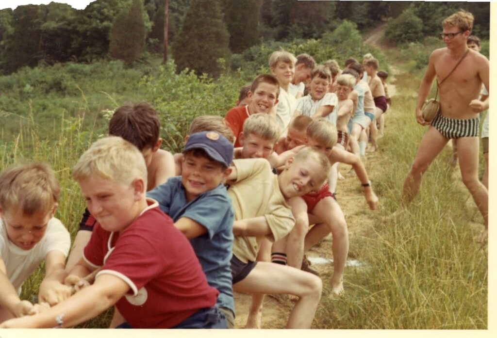 Group of boys playing tug of war outdoors.