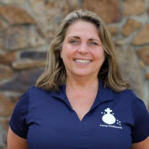 Woman smiling in blue Camp Ondessonk shirt.