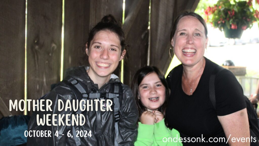 Mother and two daughters smiling at event