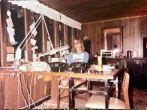 Woman working at a cluttered desk.