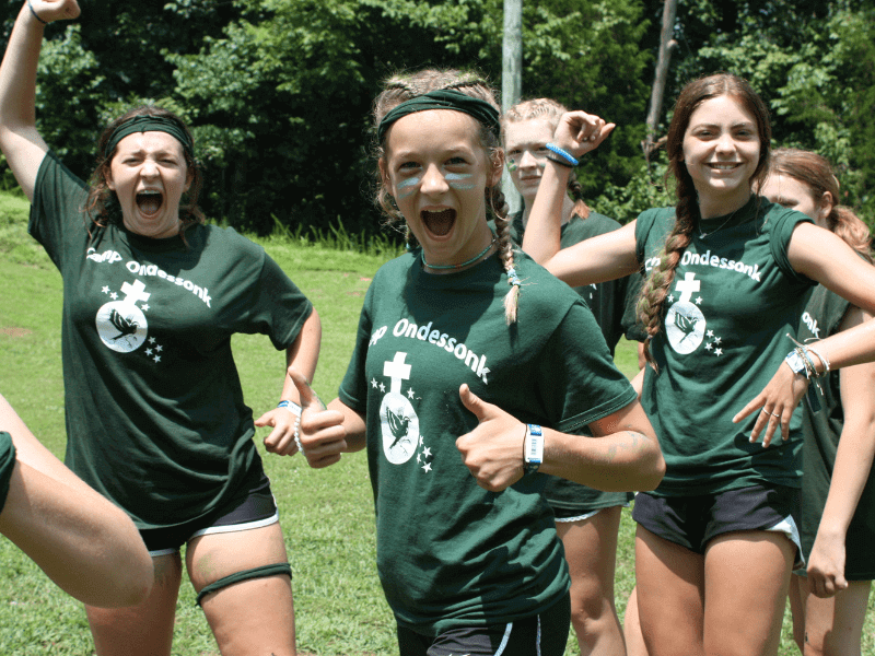 Group of girls in green camp shirts.