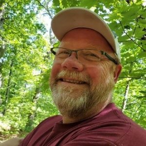 Smiling man with glasses and beard.