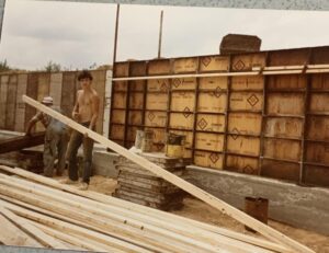 Two men working on a wooden structure.