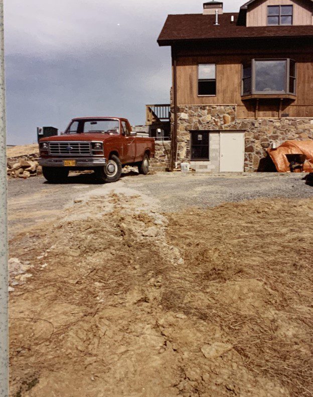 Red pickup truck parked near a house.