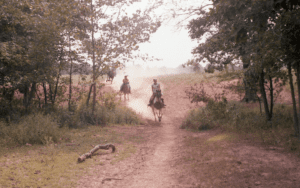 Three horseback riders on a trail.