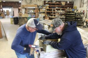 Two men working on a wooden project.