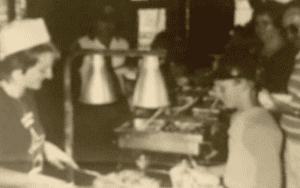 Sepia photo of people serving food.