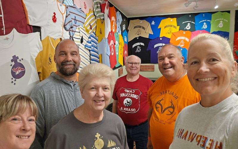 Group of smiling adults in t-shirt shop