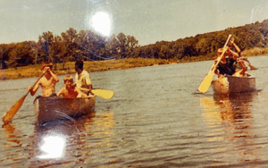 Boys canoeing on a lake at summer camp.