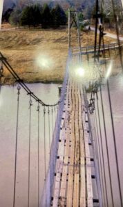 Suspension bridge over river from above.