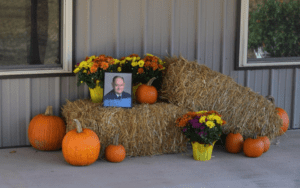 Memorial with pumpkins and flowers.