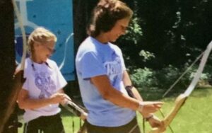 Two people practicing archery outdoors