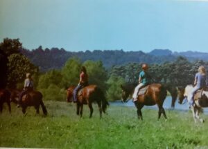 Girls horseback riding scenic landscape.
