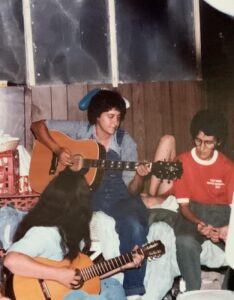 Three teens playing guitars indoors.
